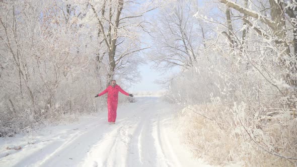 A Man Walks Through a Winter Forest with Snow Covered Trees on a Beautiful Frosty Morning