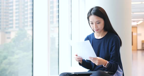 Woman reading on paper note in university campus