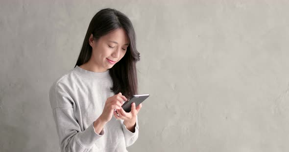 Woman use of smart phone over grey background