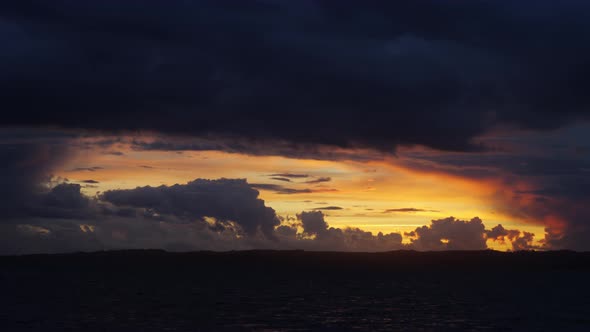 Panoramic View of Orange Skies with Puffy Clouds with the Calm Sea Beneath It