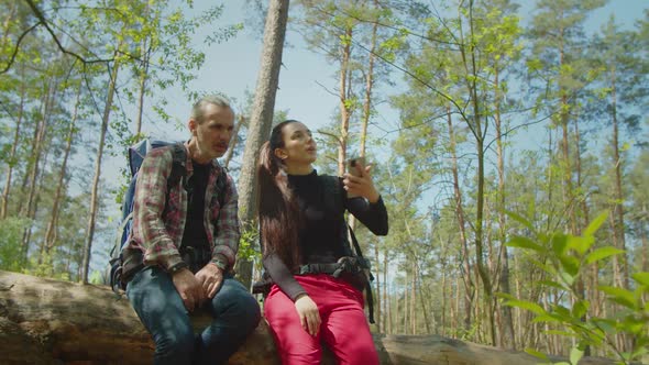 Diverse Backpackers Catching Mobile Phone Signal in Forest