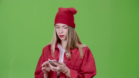 Teenager Looks at the Pictures in the Phone and Shows a Thumbs Up. Green Screen. Slow Motion