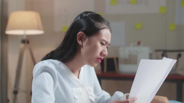 Upset Asian Woman Bag Designer Positively Shaking Her Head While Looking At The Layout Bond