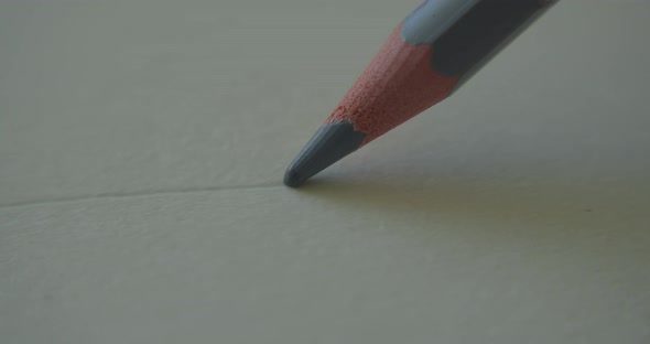 A Pencil Stem Which is Made of Grey Graphite Draws a Straight Line on a White Background of Paper