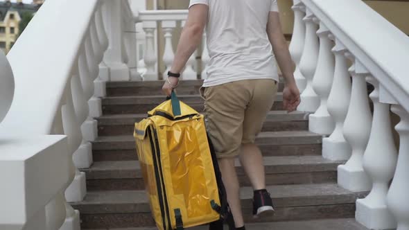 Delivery Man Courier Arrives at Residential Address To Deliver Food