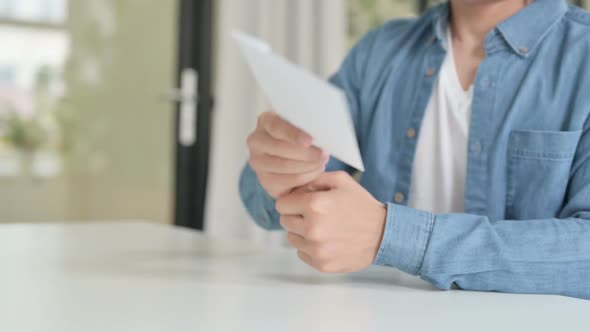 Close Up of Male Accepting Envelop and Reading Paper