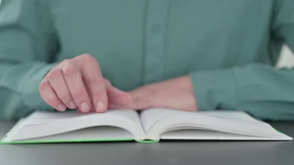 Close Up of Man Turning Pages of Book