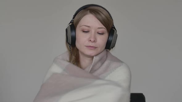 Sick Caucasian Young Woman Wrapping Herself in Blanket and Coughing, Ill Girl in Headphones