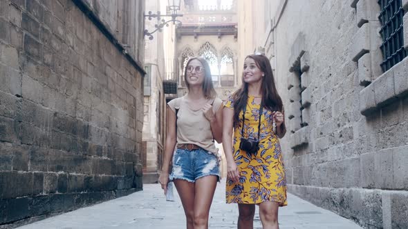 Female tourists with map walking through old town, Barcelona, Spain