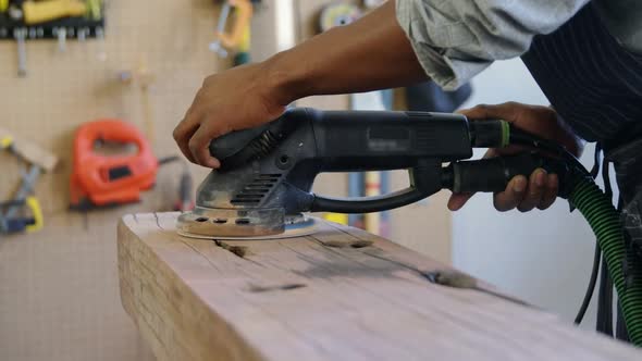 Carpenter polishing wood with machine 4k