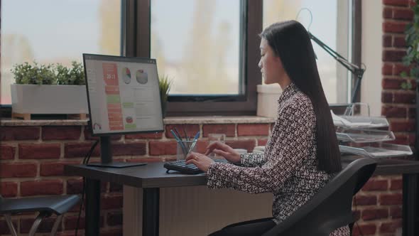 Asian Woman Using Computer to Plan Business Strategy