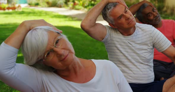 Senior friends doing exercise in garden 4k