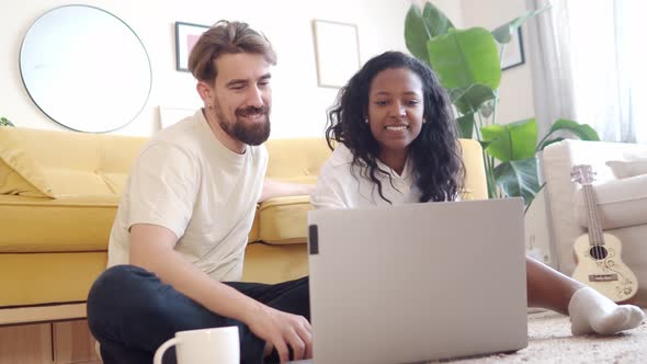 Young Multiethnic Heterosexual Couple at Home Using a Laptop