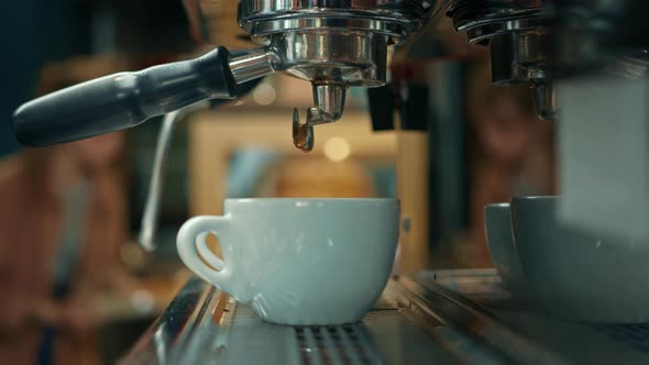 Making a cup of strong coffee in a coffee machine, the back light illuminates the steam and the cup.