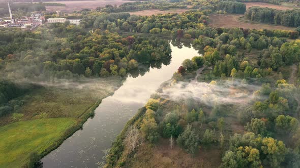 The Fog Slowly Floats Over the River on a Quiet Summer Evening  Tilt Reveal Drone Shot