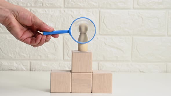 hand with a blue magnifying glass examines unique and talented