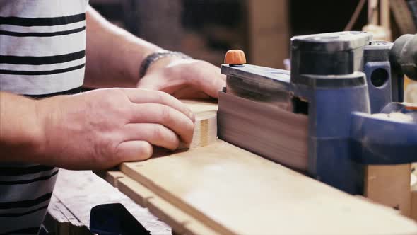 Craftsman Working with Grinding Machine at Wood Workshop, Hands Closeup.