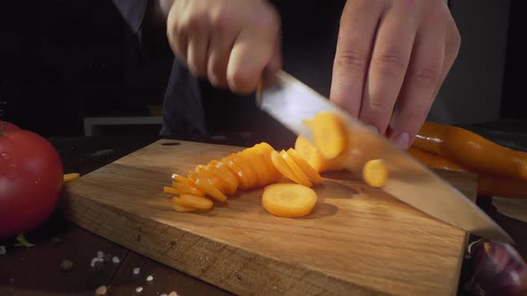 Zooming Shot of Chopping Raw Carrot on the Wooden Board, Cutting Vegetables, Slicing of the Food