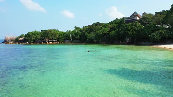 Tropical birds eye clean view of a sunshine white sandy paradise beach and aqua turquoise water 