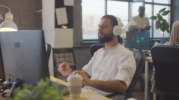 Man Putting on Headphones in Office