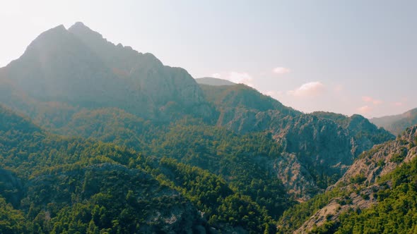 High Mountains Peak Covered with Green Forest Lit By Sunrays