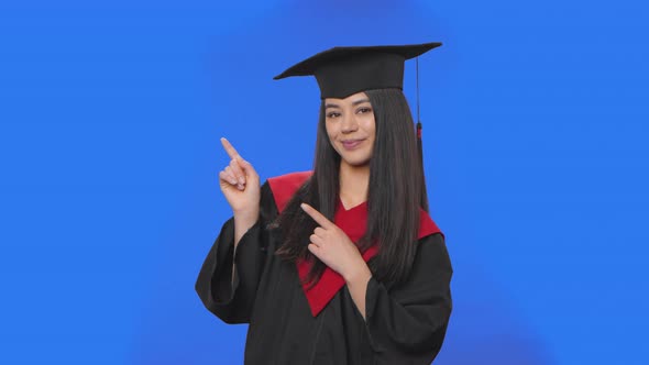 Portrait of Female Student in Graduation Costume Pointing Side Hand for Something Then Nods and
