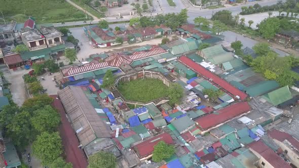 Camera Rises Over Tiny Meadow Amidst Small Village By River