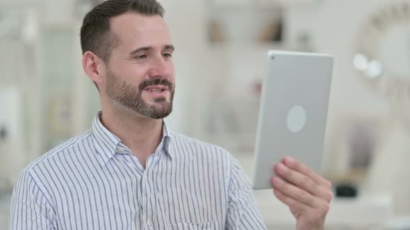 Portrait of Video Call on Tablet By Attractive Young Man 