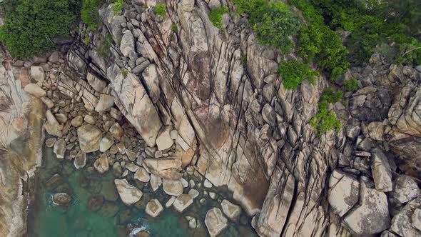 Aerial View of Island Beach with Bungalow and Rocky Coastline at Haad Khom Beach