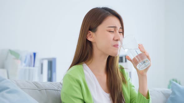 Asian beautiful woman feel terrible toothache after drink cold water.