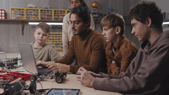 Teacher And Students Watching Something On Laptop