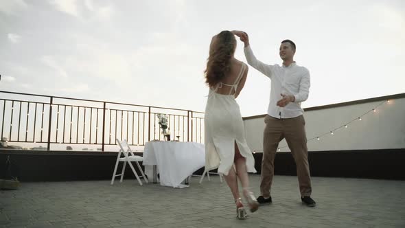 Young Couple Dancing on the Roof at Sunset Super Slow Motion