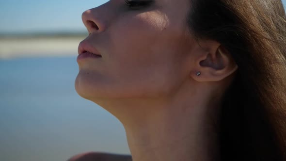 The Face of a Very Beautiful Girl Looking in the Frame Against the Blue Sky