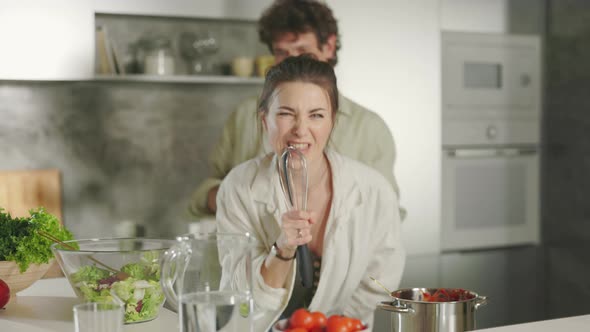 Crazy Young Couple Cooking on Kitchen with Song and Dance