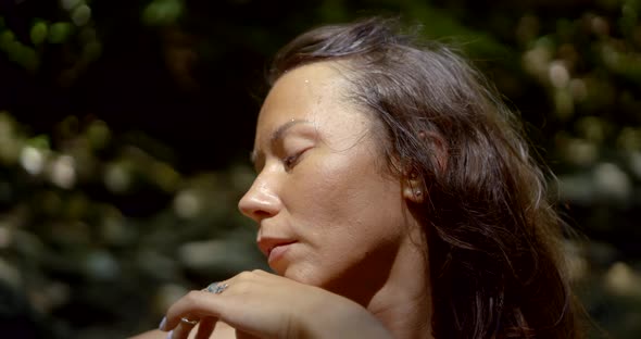 Young Beautiful Woman Lit By Sunlight Dances in Summer Close