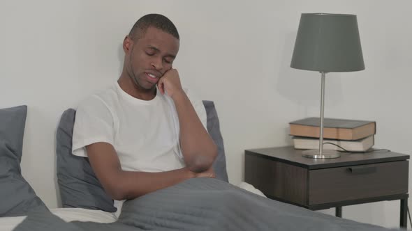 African Woman Taking Nap While Sitting in Bed