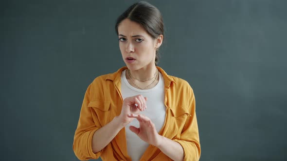 Slow Motion of Scared Young Woman Hiding Face Behind Hands and Looking at Camera with Fear