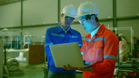 Male Asian engineer professional  having a discussion standing consult cnc machine