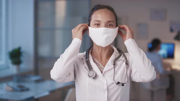 Woman Putting On Protective Mask