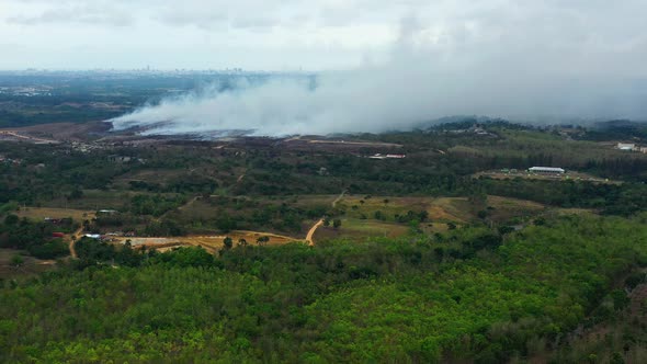 Aerial, drone shot, towards a Grass fire burning, a huge toxic smoke cloud causing global warming an