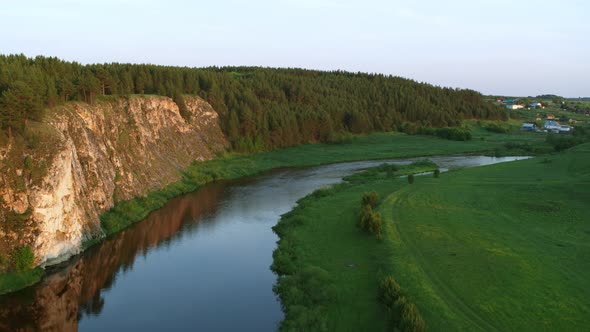 Aerial View of the River with a Rock and Forest on the Banks