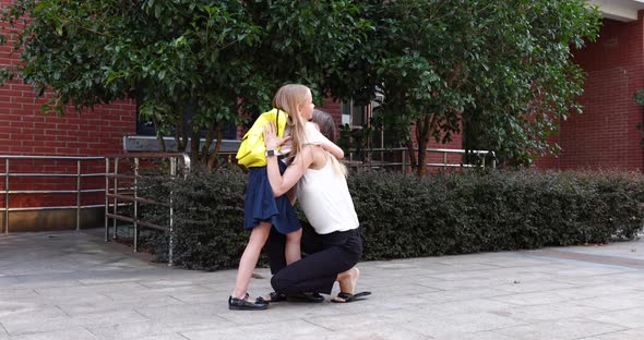 Happy Little Caucasian Blonde Girl Seven Years Old in Uniform with Yellow Backpack Going Back to