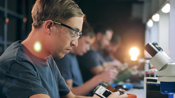 Service People Sitting Row Fixing Electronics Workshop