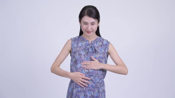 Happy Pregnant Asian Woman Pointing at Camera