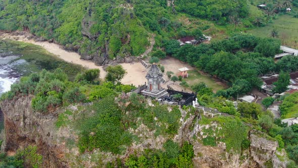 Serene aerial view on Buddhist temple on cliff by Ngobaran beach, Indonesia