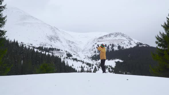 A Man Dances in the Mountains in Winter