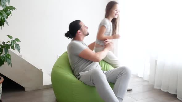 Close Up of Cheerful Teen Girl with Long Hair is Hugging Her Dad and Laughing in the Living Room at