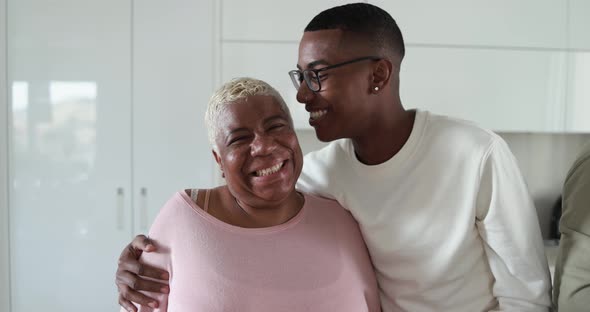 African mother and son having tender moment inside kitchen at home - Family love concept