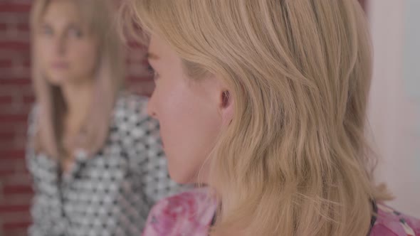 Portrait of Upset Beautiful Caucasian Woman with Grey Eyes Looking Back at Her Friend and Away