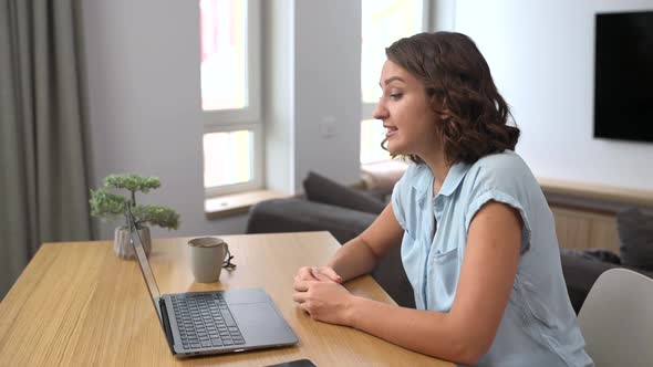 Smiling Caucasian Woman Waving at the Laptop Screen Staying Connected During Pandemic